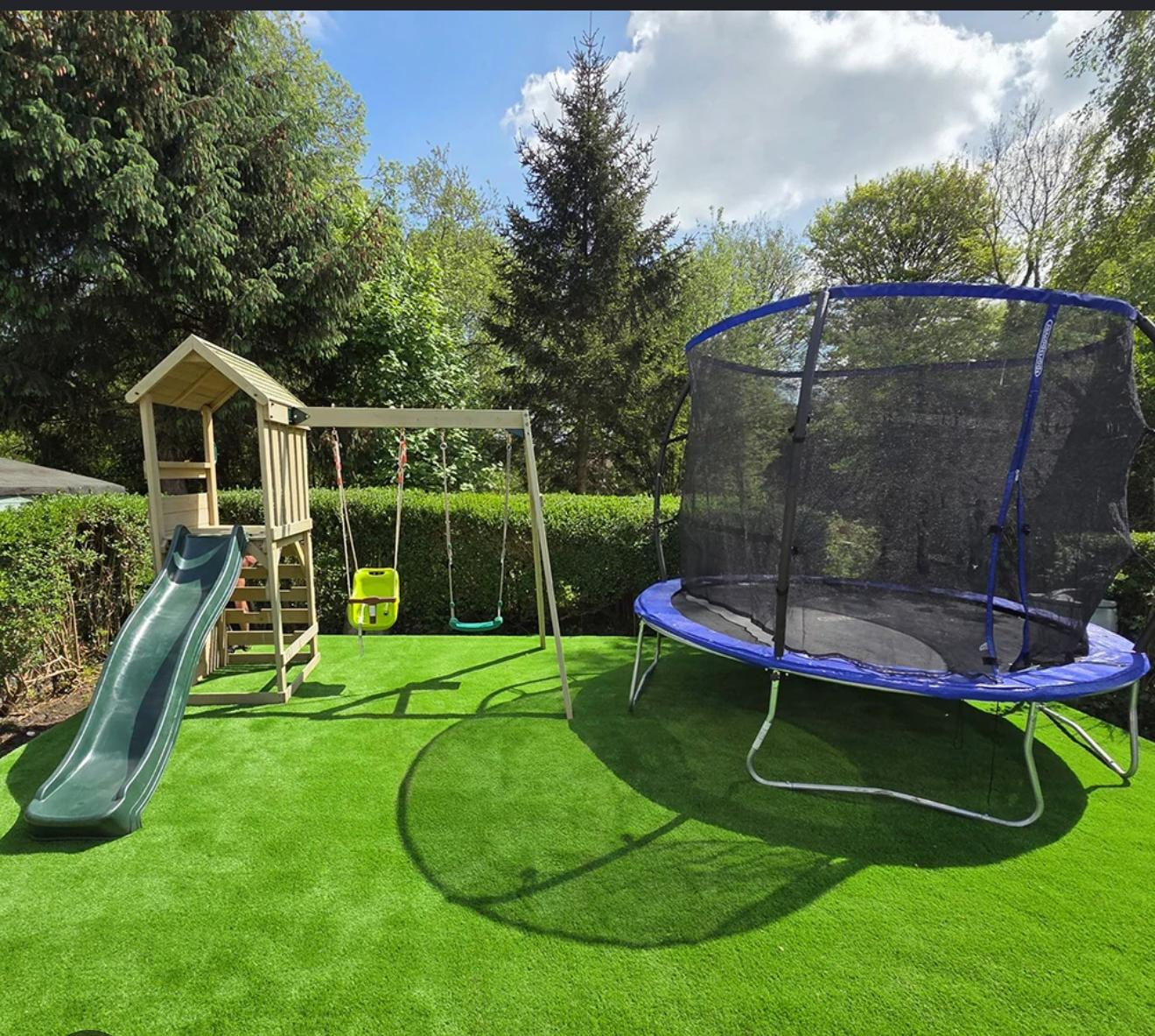 Artificial grass in a garden with a swing set and trampoline